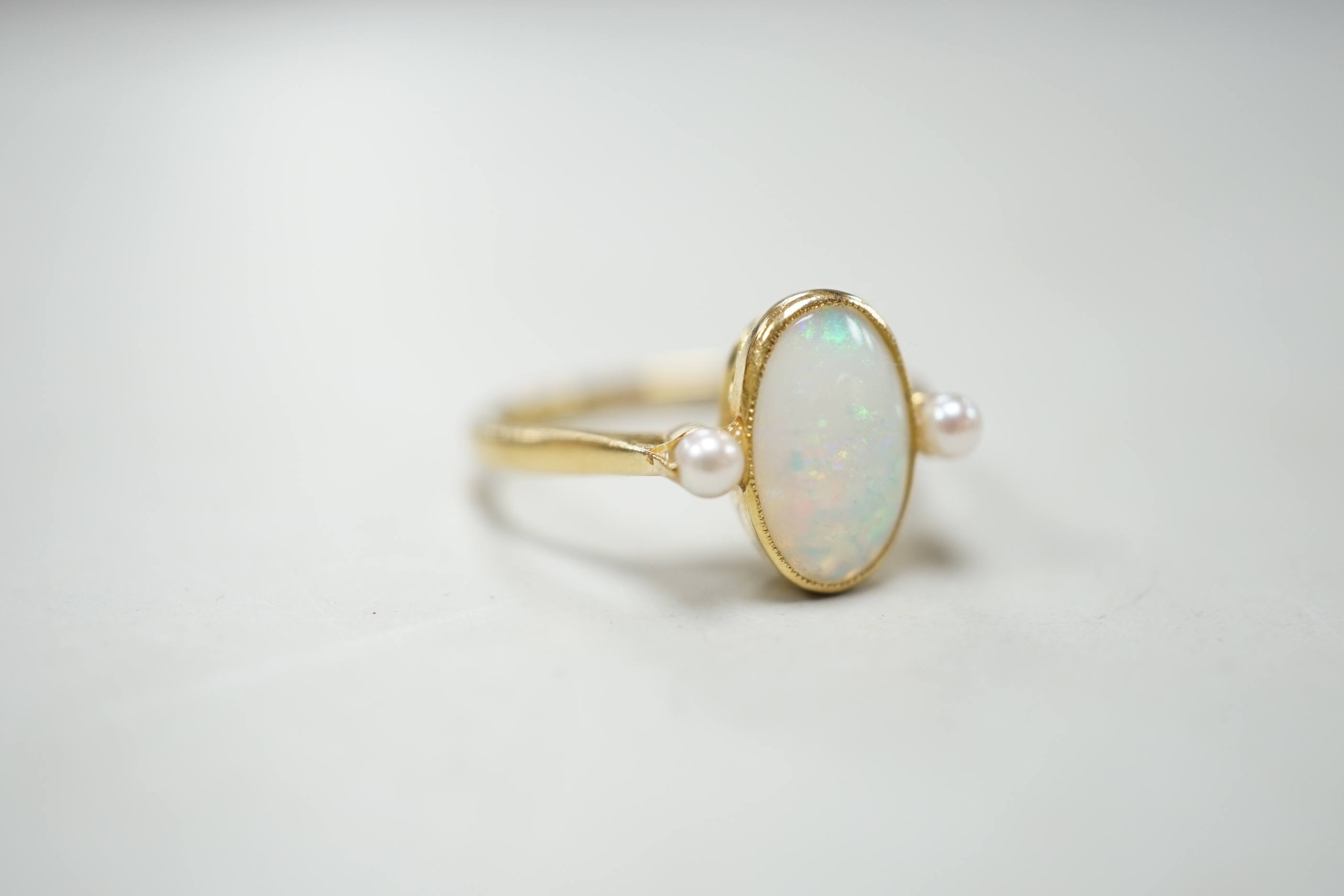 An 18ct, white opal and cultured pearl set three stone ring, size M, gross weight 3.1 grams.